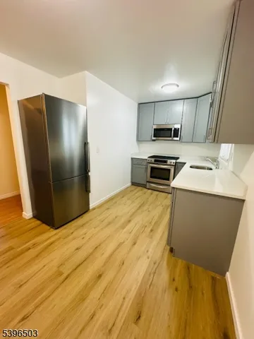 a kitchen with stainless steel appliances granite countertop a refrigerator a stove and a sink