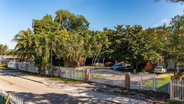 a view of a yard with wooden fence