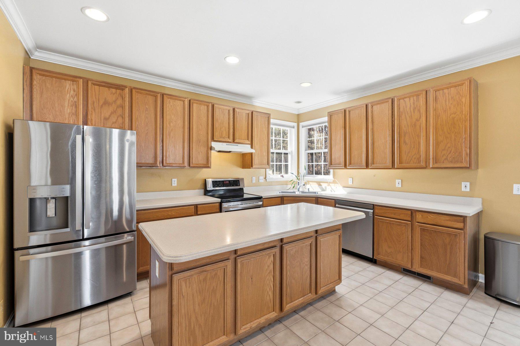 7810 Grandison Way Severn, MD 21144 - Photo 14 of 50 a kitchen with stainless steel appliances granite countertop a refrigerator sink and cabinets