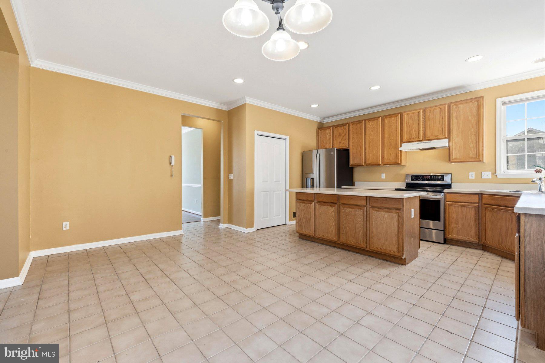 7810 Grandison Way Severn, MD 21144 - Photo 16 of 50 a kitchen with stainless steel appliances a sink a stove a refrigerator cabinets and a window