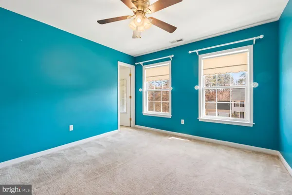 a view of empty room with window and ceiling fan