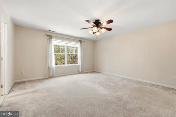 an empty room with closet and a ceiling fan