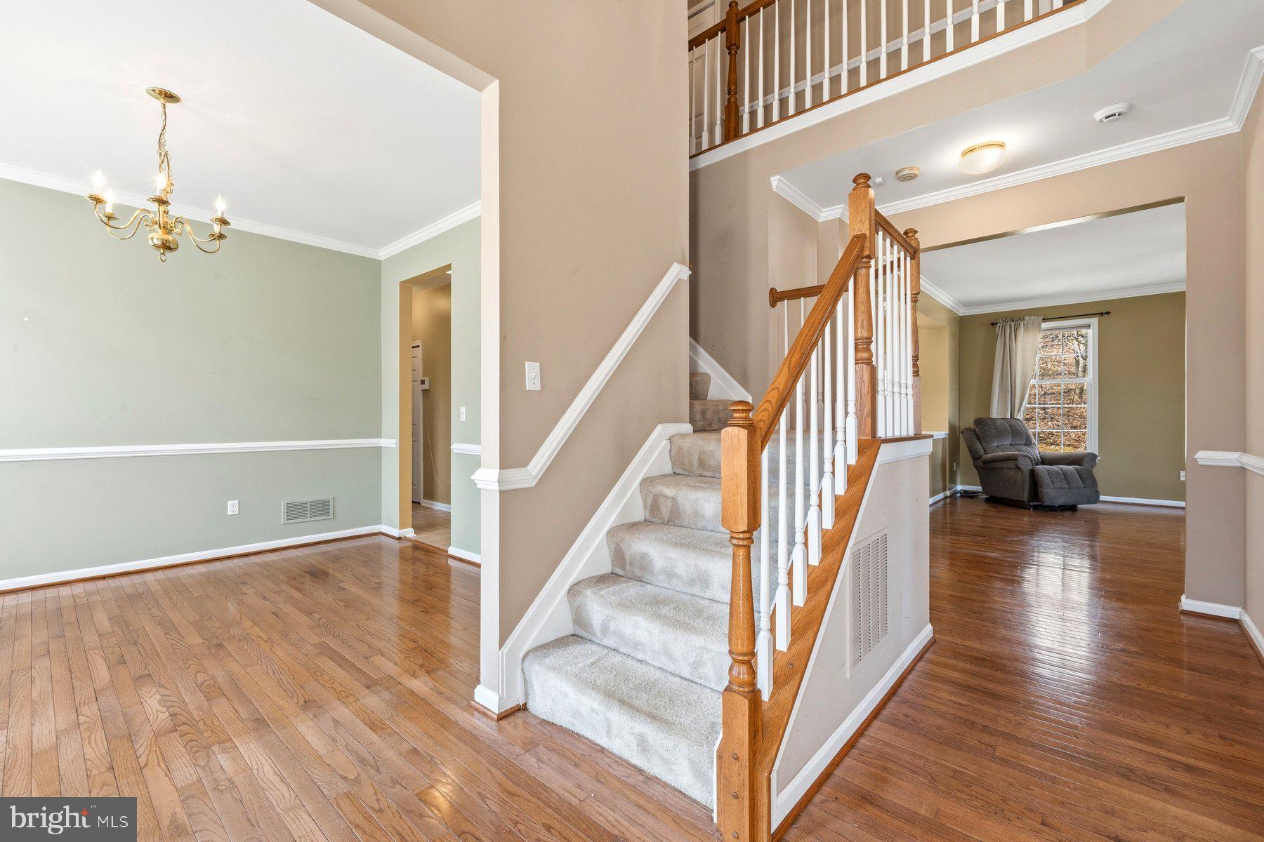 7810 Grandison Way Severn, MD 21144 - Photo 3 of 50 a view of a hallway view with wooden floor and staircase