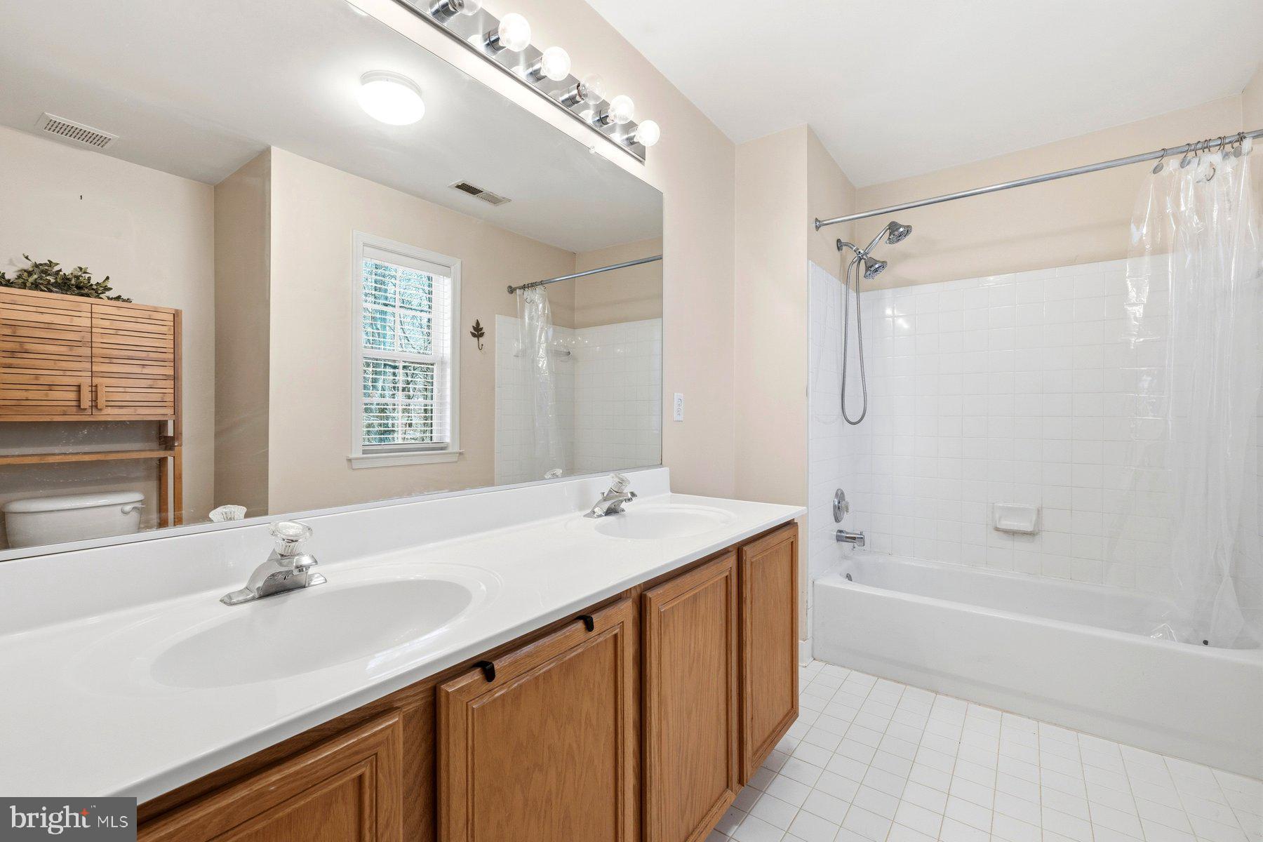 7810 Grandison Way Severn, MD 21144 - Photo 36 of 50 a bathroom with a sink double vanity granite tub shower and a mirror