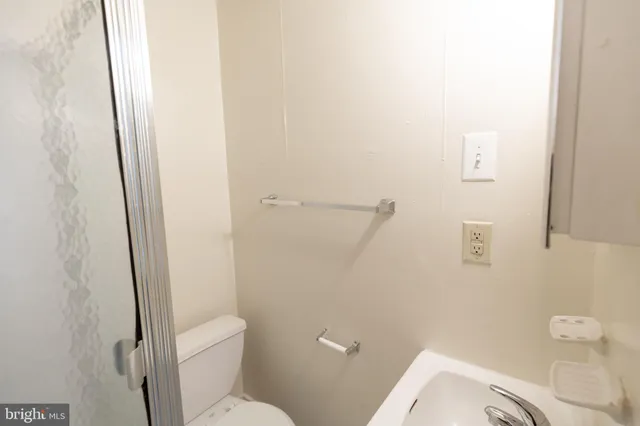 a white toilet sitting next to a shower