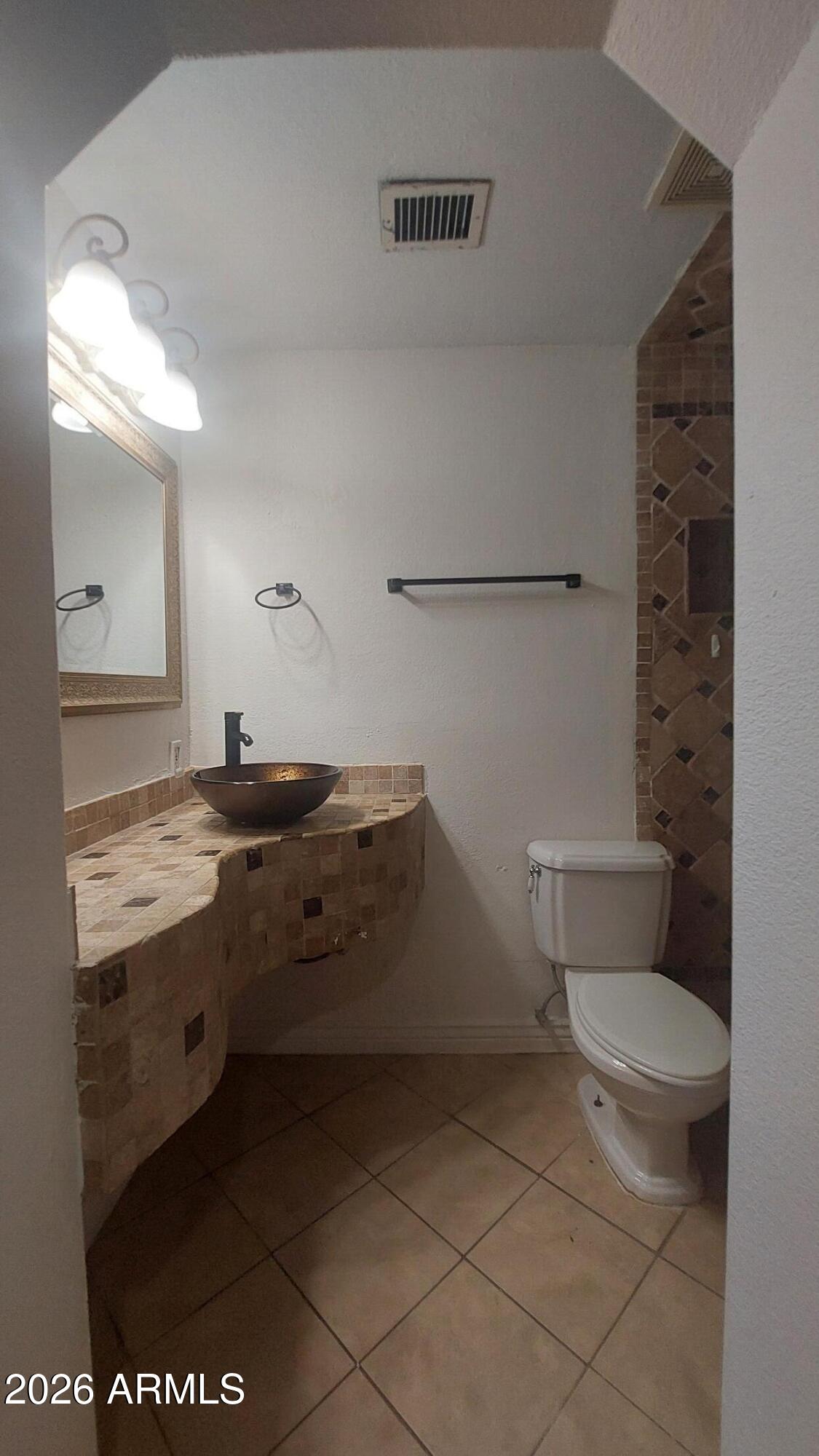 2448 West Freeway Lane Phoenix, AZ 85021 - Photo 18 of 27 a bathroom with a granite countertop sink a toilet a mirror and shower