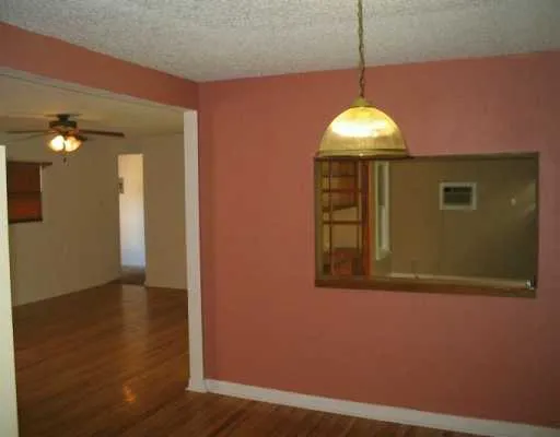 a view of a livingroom with wooden floor and a window