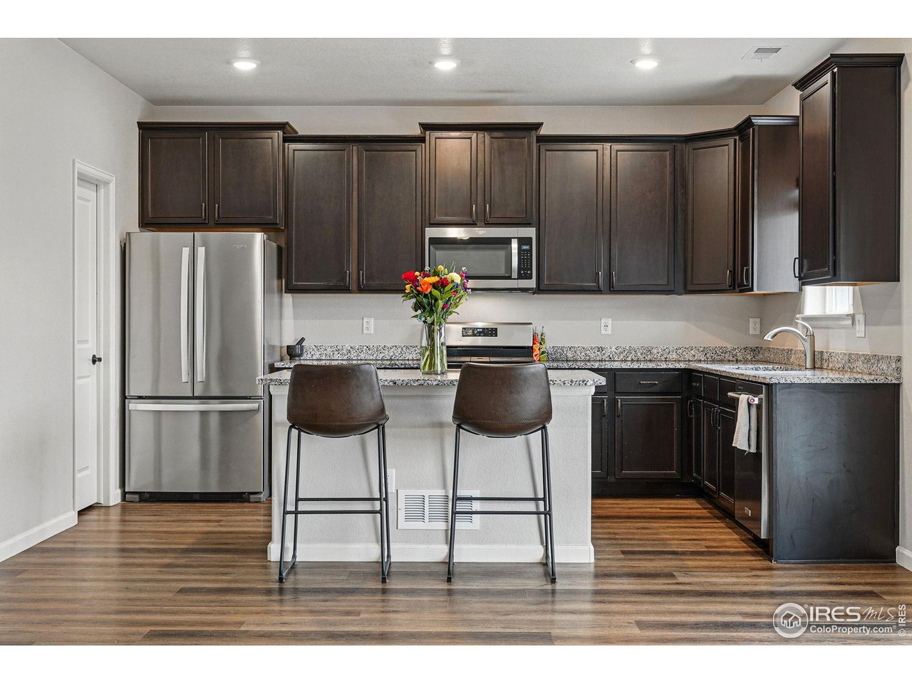 2310 Angus Street Mead, CO 80542 - Photo 12 of 39 a kitchen with granite countertop a refrigerator and a stove top oven