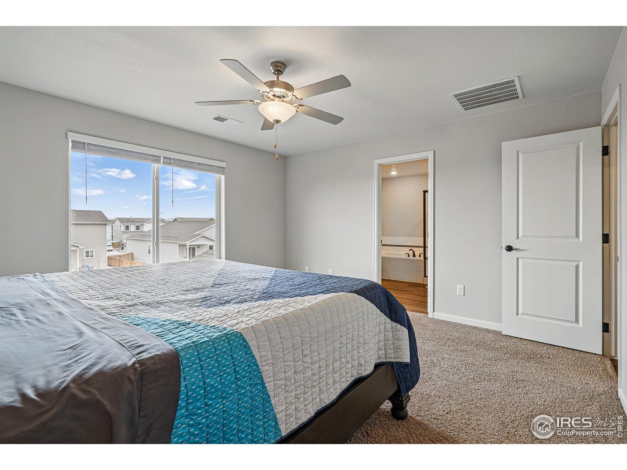 2310 Angus Street Mead, CO 80542 - Photo 22 of 39 a bedroom with a bed and a chandelier