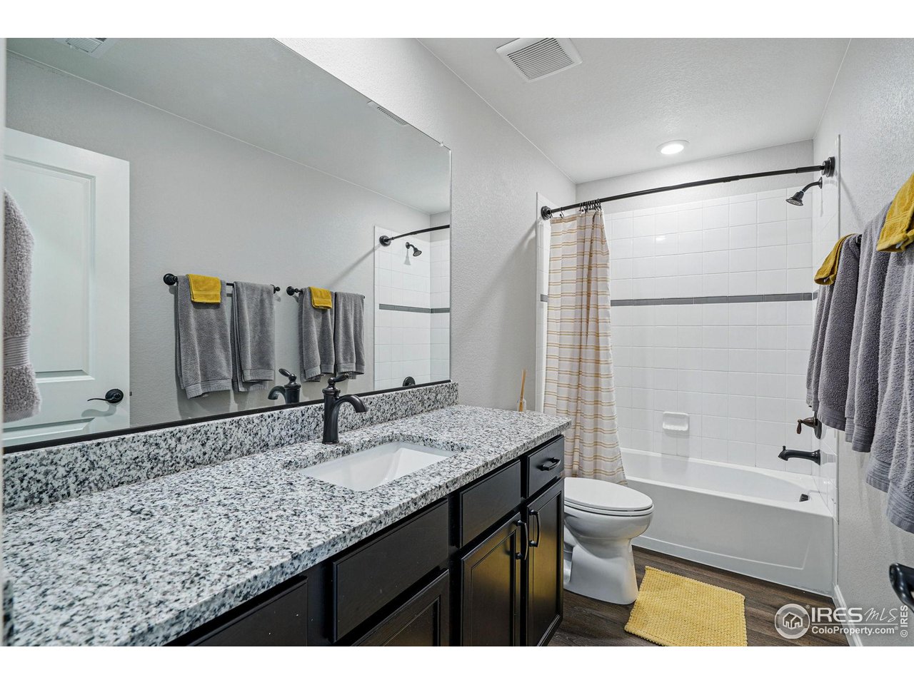 2310 Angus Street Mead, CO 80542 - Photo 30 of 39 a bathroom with a granite countertop sink toilet and shower