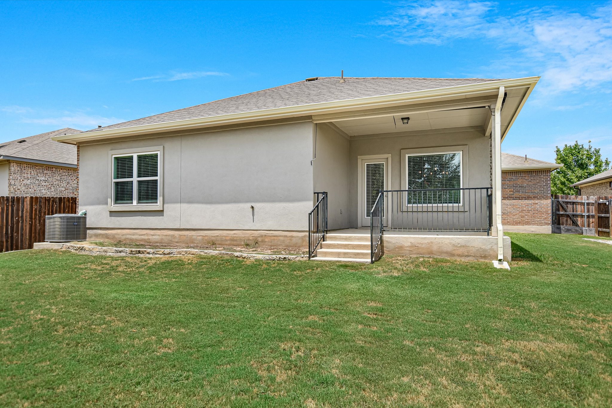 4300 Porter Farm Road Georgetown, TX 78628 - Photo 30 of 36 A well-maintained lawn offers ample space for outdoor enjoyment behind this stucco home with a covered patio.