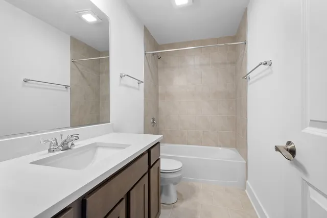 a bathroom with a shower sink vanity mirror and toilet