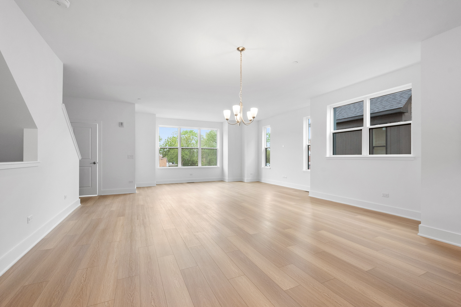 8375 Mulberry Avenue Morton Grove, IL 60053 - Photo 4 of 24 an empty room with wooden floor chandelier and windows