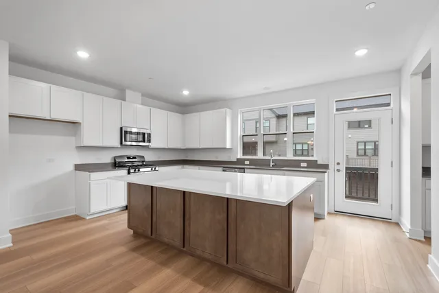 a kitchen with kitchen island granite countertop a sink and cabinets