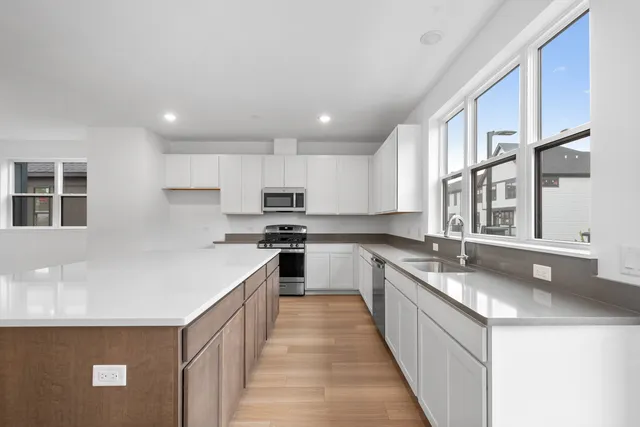 a kitchen with stainless steel appliances granite countertop a sink stove and cabinets