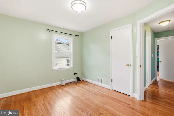 a view of a room with wooden floor and window
