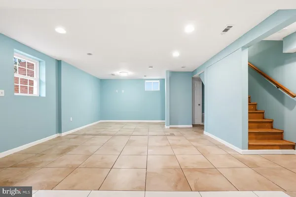 a view of an empty room with stairs and ventilation