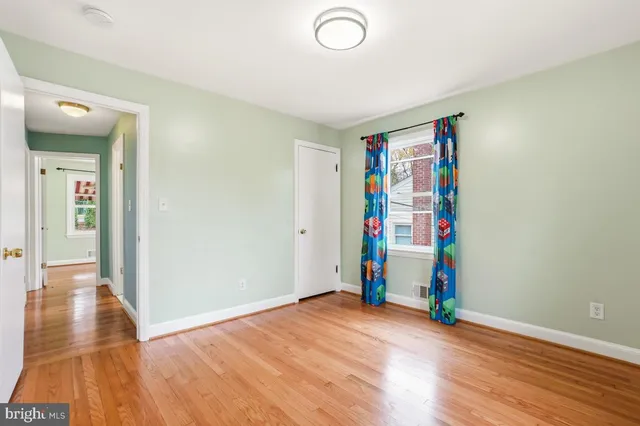 a view of an empty room with wooden floor