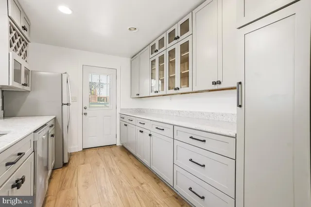 a kitchen with cabinets and wooden floor