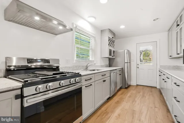 a kitchen with granite countertop a stove top oven and sink