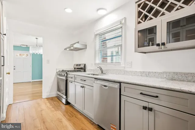 a kitchen with stainless steel appliances granite countertop a sink and a stove