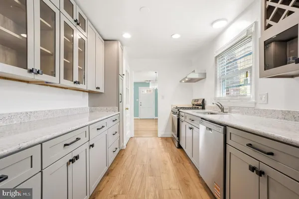 a large kitchen with granite countertop a large counter top space a sink stainless steel appliances and cabinets