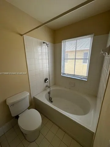 a bathroom with a granite countertop toilet a sink and bathtub