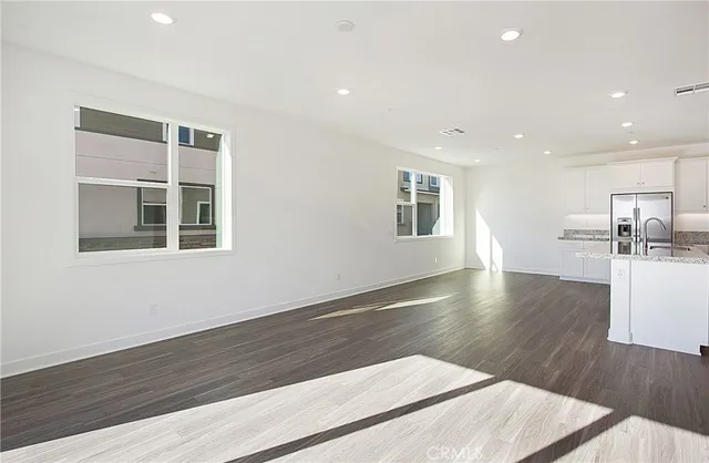 a view of a kitchen with wooden floor and a window