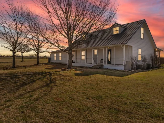 a front view of house with yard and trees around