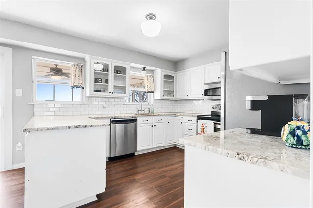 a kitchen with stainless steel appliances granite countertop a stove and cabinets