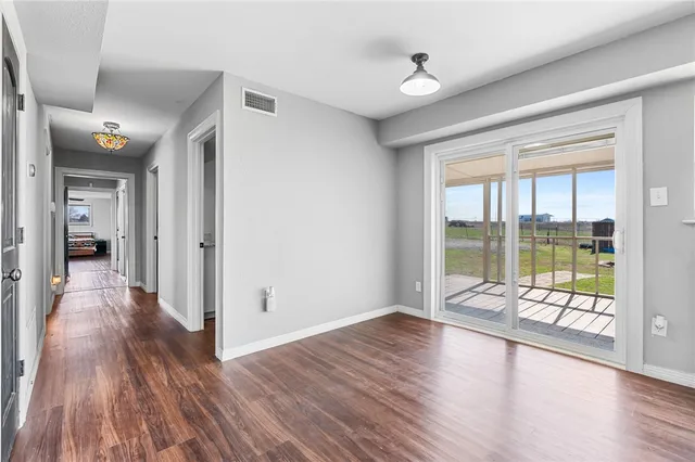 a view of hallway with livingroom and wooden floor