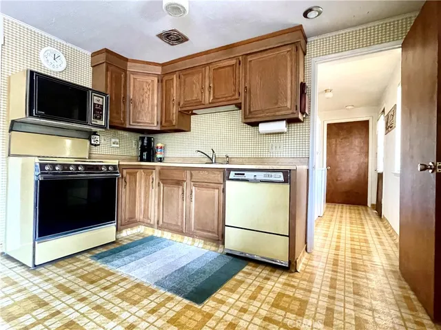 a kitchen with stainless steel appliances granite countertop a stove a sink and a microwave