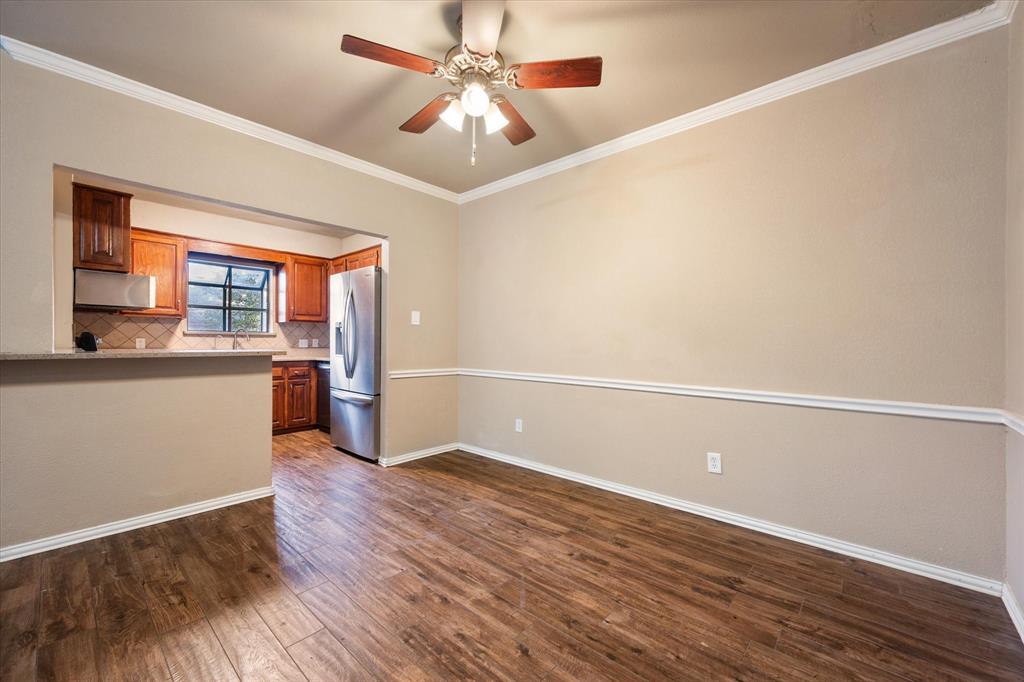 2312 Perkins Road Arlington, TX 76016 - Photo 14 of 37 a view of a kitchen with wooden floor and a ceiling fan