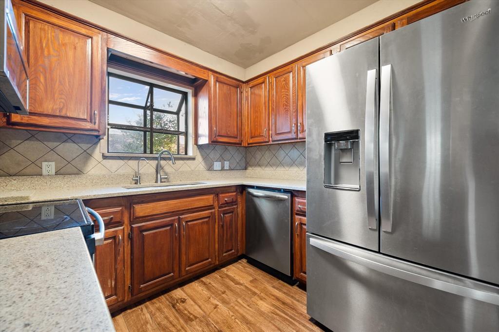 2312 Perkins Road Arlington, TX 76016 - Photo 16 of 37 a kitchen with stainless steel appliances granite countertop a refrigerator and a sink