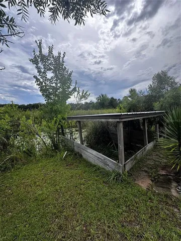 a view of a yard with wooden fence