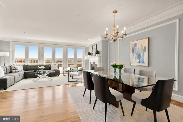 a view of a dining room with furniture a chandelier and wooden floor