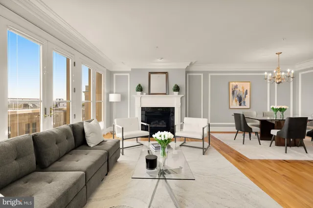 a living room with furniture fireplace and a large window
