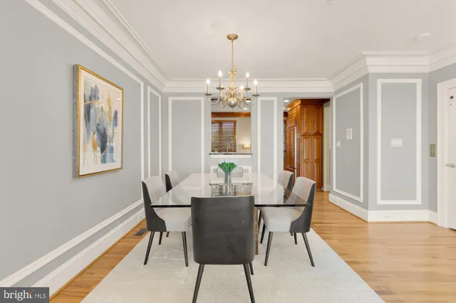 a dining room with furniture a chandelier and wooden floor