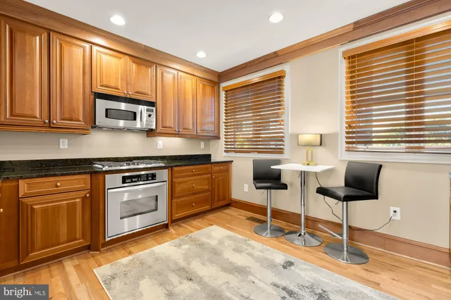 a kitchen with stainless steel appliances granite countertop a stove a sink and a microwave