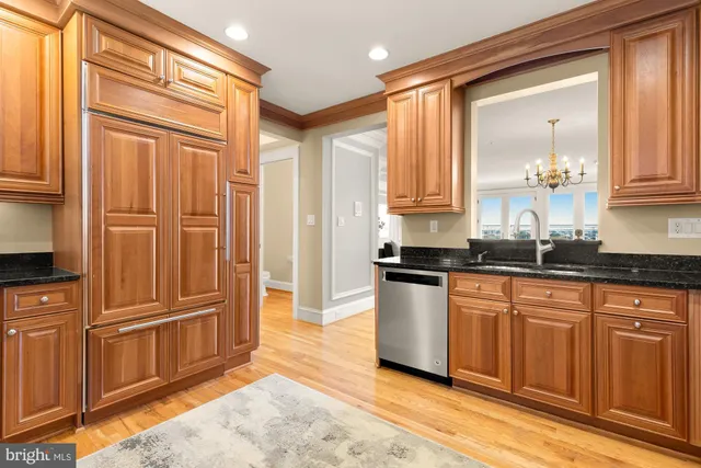 a large kitchen with granite countertop a refrigerator and a sink