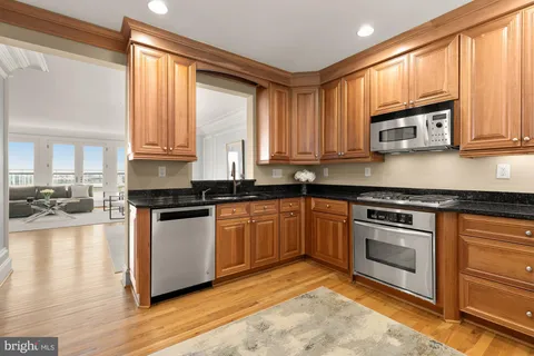 a kitchen with stainless steel appliances granite countertop a stove a sink and a microwave