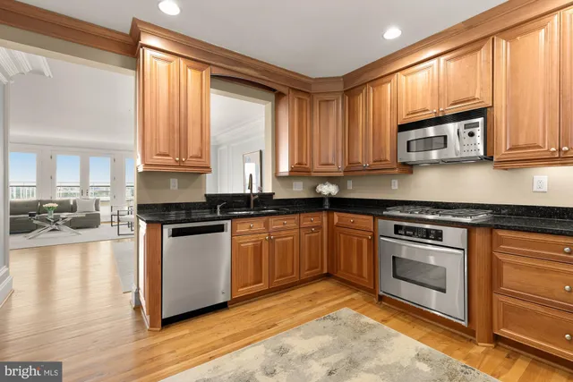 a kitchen with stainless steel appliances granite countertop a stove a sink and a microwave