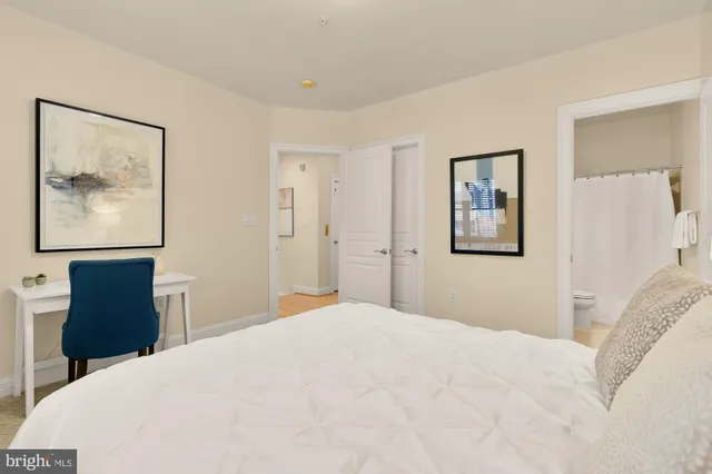 a bedroom with a large bed and a chandelier