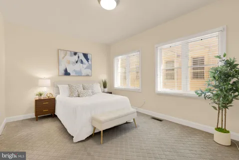 a bedroom with a bed and a potted plant