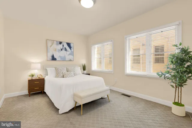 a bedroom with a bed and a potted plant