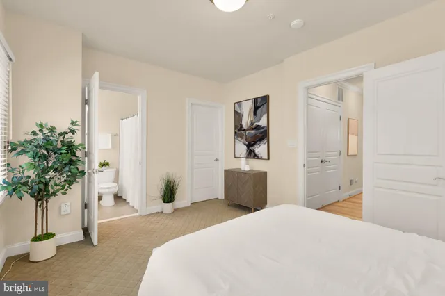 a bedroom with a bed and a potted plant