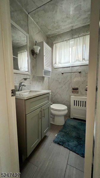 554 Second Avenue, Unit 1 Lyndhurst, NJ 07071 - Photo 3 of 11 a bathroom with a granite countertop sink a toilet a mirror and a window