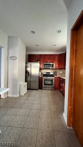 554 Second Avenue, Unit 1 Lyndhurst, NJ 07071 - Photo 5 of 11 a kitchen with stainless steel appliances granite countertop a refrigerator and a stove