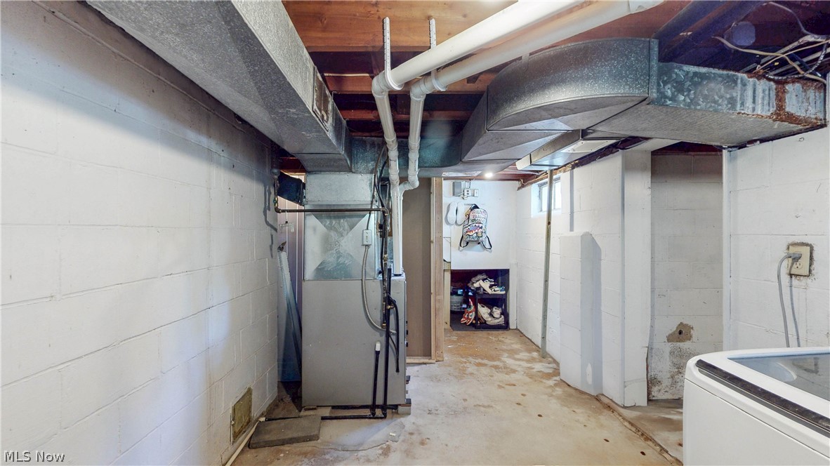 3659 Morrow Road Kent, OH 44240 - Photo 30 of 39 Basement space featuring exposed ceiling joists and ductwork, a central forced-air unit, visible plumbing, painted block walls, and a recessed storage area