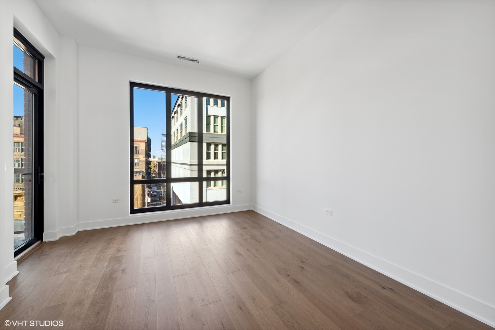 323 South Racine Avenue, Unit 6B Chicago, IL 60607 - Photo 27 of 36 an empty room with wooden floor and windows